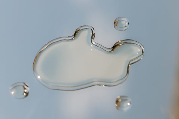 Photograph of clear gel beading on a mirror surface