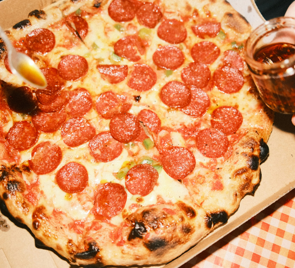 Photograph of a pepperoni pizza in a cardboard box